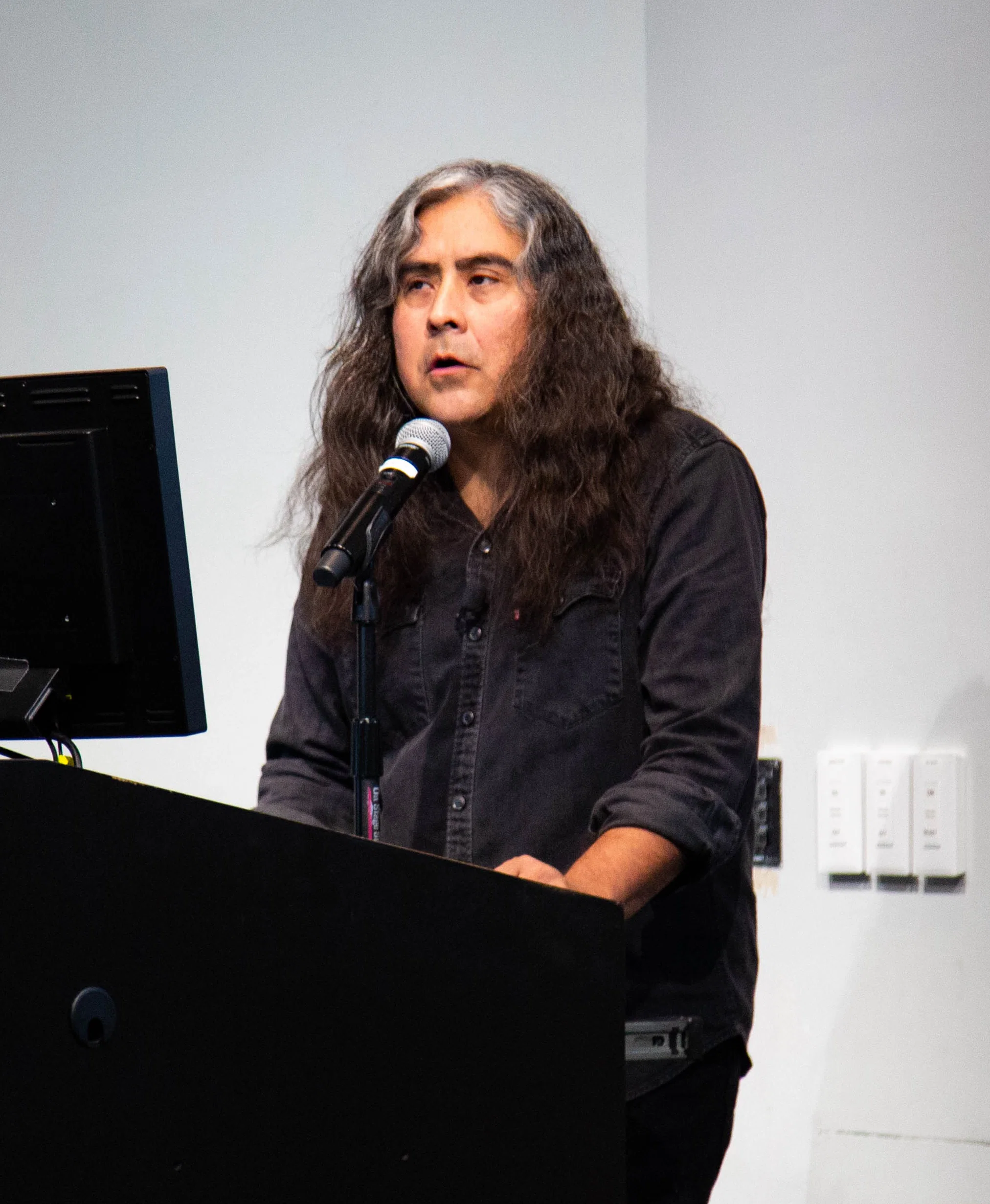 Field: featured image Raven Chacon speaking in front of an audience