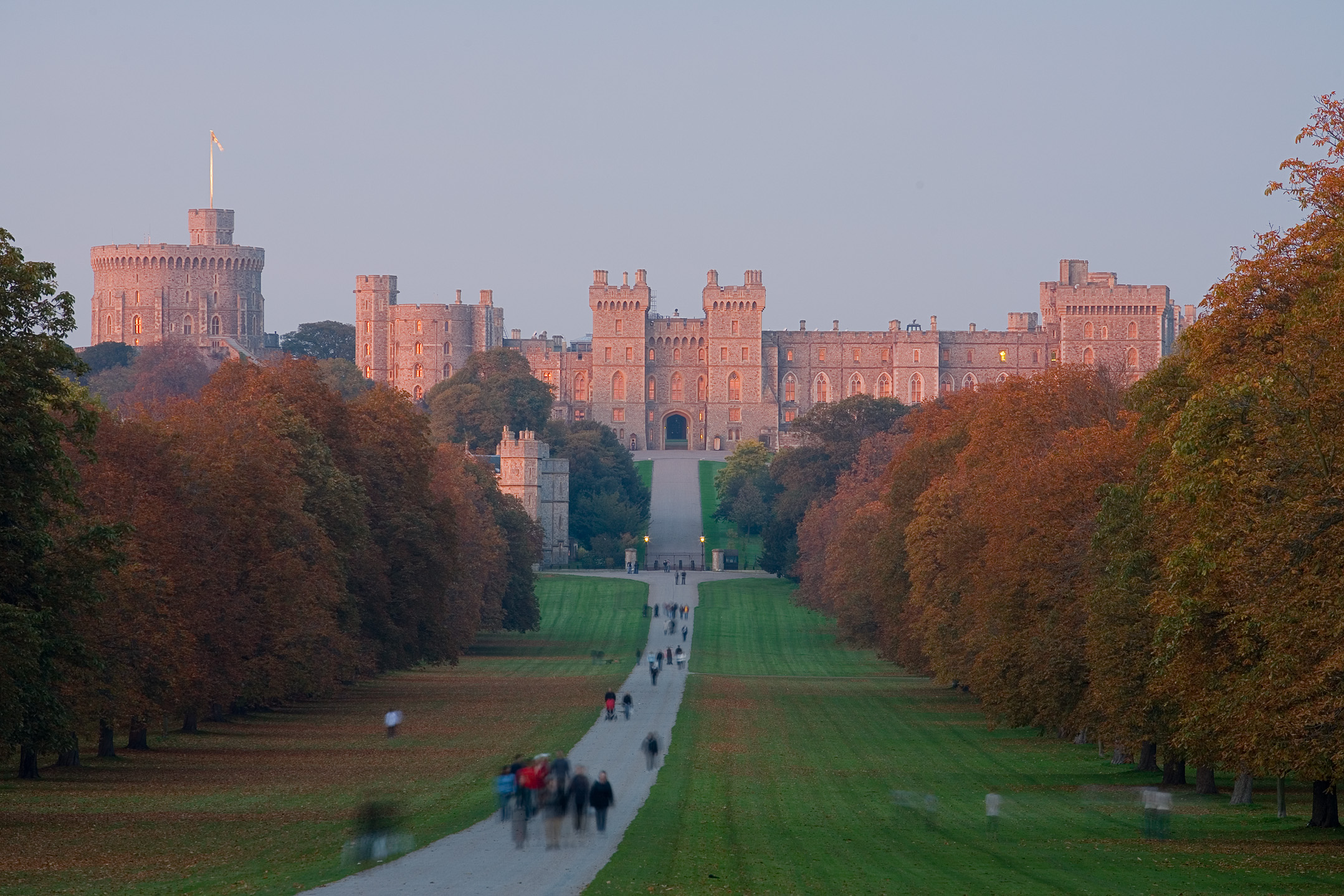 Windsor Castle illuminated by warm sunset light beneath a blue sky